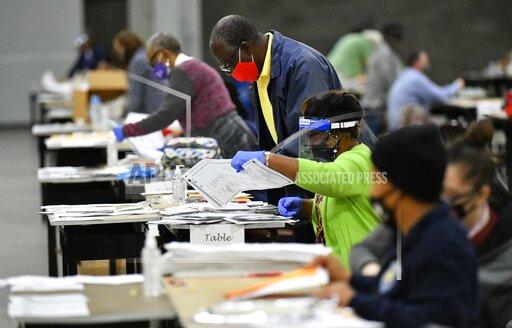 FILE - In this Saturday, Nov. 14, 2020, file photo, election workers in Fulton County began working through a recount of ballots in Atlanta. Investigators with Georgia’s secretary of state’s office have not found any evidence to substantiate claims that fraudulent or counterfeit ballots were counted in Fulton County during the 2020 general election. Henry County Superior Court Chief Judge Brian Amero is presiding over a lawsuit that alleges fraud in Fulton County during last year’s election. (Hyosub Shin/Atlanta Journal-Constitution via AP, File)
