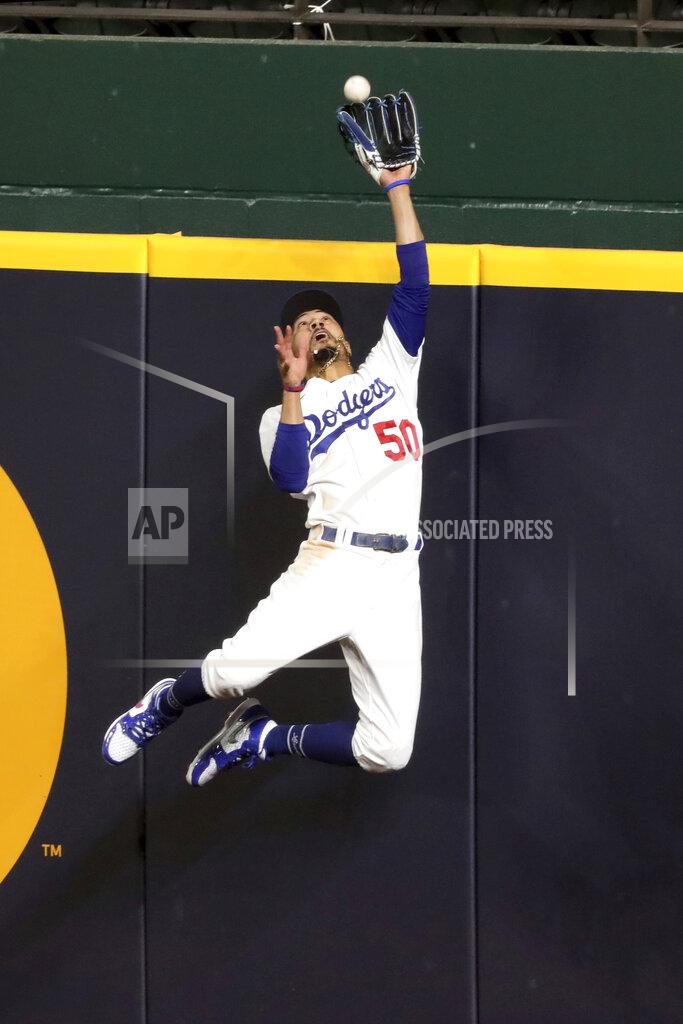 Curtis Compton Los Angeles Dodgers right fielder Mookie Betts makes a catch and robs a home run from Atlanta Braves' Freddie Freeman during the fifth inning in Game 7 of a baseball National League Championship Series, Sunday, Oct. 18, 2020, in Arlington, Texas. (Curtis Compton/Atlanta Journal-Constitution via AP)