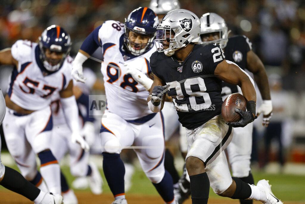 D. Ross Cameron Oakland Raiders running back Josh Jacobs runs with the ball as Denver Broncos defensive end DeMarcus Walker (57) and nose tackle Mike Purcell (98) look on during the first half of an NFL football game Monday, Sept. 9, 2019, in Oakland, Calif. (AP Photo/D. Ross Cameron)
