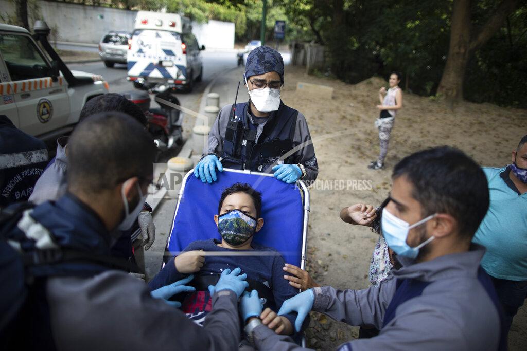 Ariana Cubillos Wearing masks to curb the spread of the new coronavirus, Angels of the Road volunteer paramedics take a boy on a stretcher to their ambulance after he was involved in a motorcycle accident in Caracas, Venezuela, Thursday, Feb. 4, 2021. Despite receiving no paychecks, its roughly 40 paramedics are ready at a moment’s notice to jump onto motorcycles and fire up their single ambulance and race into the streets. (AP Photo/Ariana Cubillos)