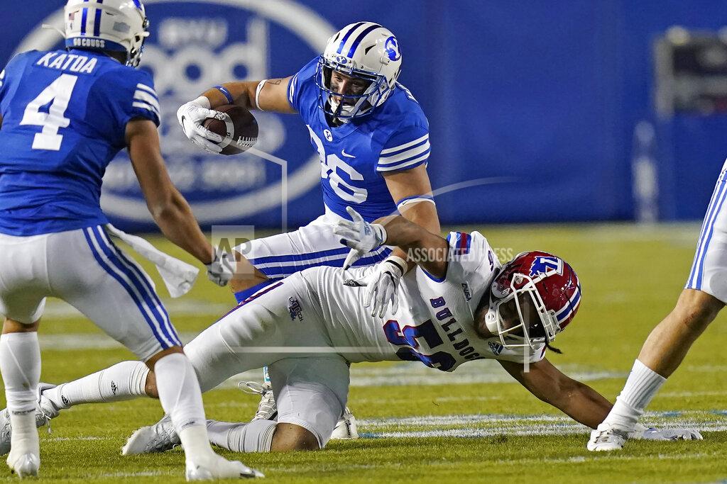 Rick Bowmer BYU tight end Carter Wheat, rear, is tackled by Louisiana Tech defensive lineman Mykol Clark (56) during the first half of an NCAA college football game Friday, Oct. 2, 2020, in Provo, Utah. (AP Photo/Rick Bowmer, Pool)