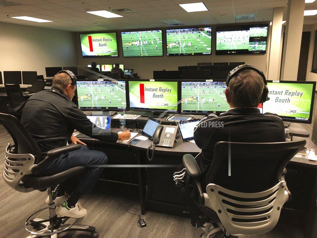 Greg Burks, left, the Big 12 coordinator of football officials, and David Warden, the Big 12's replay coordinator, sit in the conference's centralized replay center in Irving, Texas, Thursday, Oct. 25, 2018. In the background at rear left, at one of the centers six game stations, is the two-man crew assigned specifically to cover the Baylor-West Virginia NCAA college football game. (AP Photo/Stephen Hawkins)