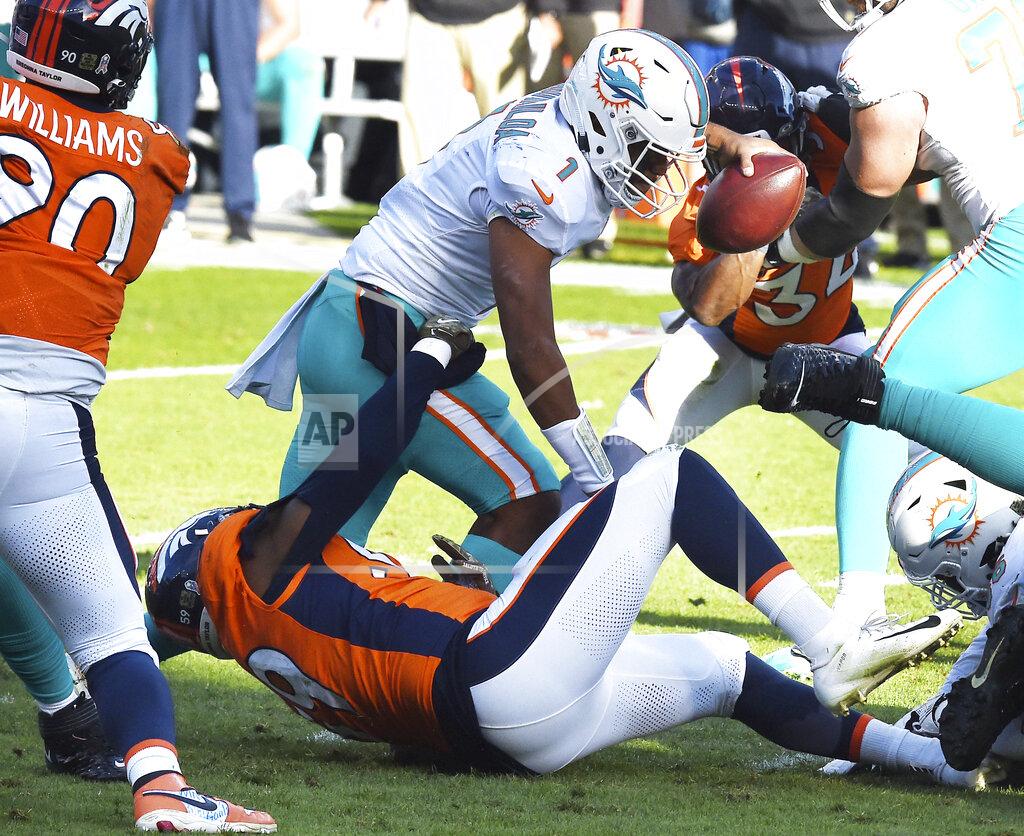Jerilee Bennett Denver Broncos linebacker Malik Reed, bottom, sacks Miami Dolphins quarterback Tua Tagovailoa, top, in the first half of an NFL football game in Denver, Sunday, Nov. 22, 2020. (Jerilee Bennett/The Gazette via AP)