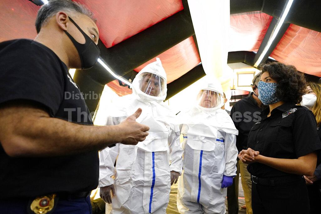 Harris County Public Health Executive Director Dr. Umair A. Shah, left, talks with Harris County Judge Lina Hidalgo, right, inside the intensive care unit during a tour of the new Harris County Non-Congregate Medical Shelter at NRG Park as Dr. Suchmor Thomas, center left, and nurse Kevin Anderson listen, Saturday, April 11, 2020, in Houston. The new temporary setup will have 250 beds initially with a capacity of 2000 beds, if needed, to help relieve pressure on the hospital system from COVID-19 patients. Activation is not intended at this time. (AP Photo/David J. Phillip)