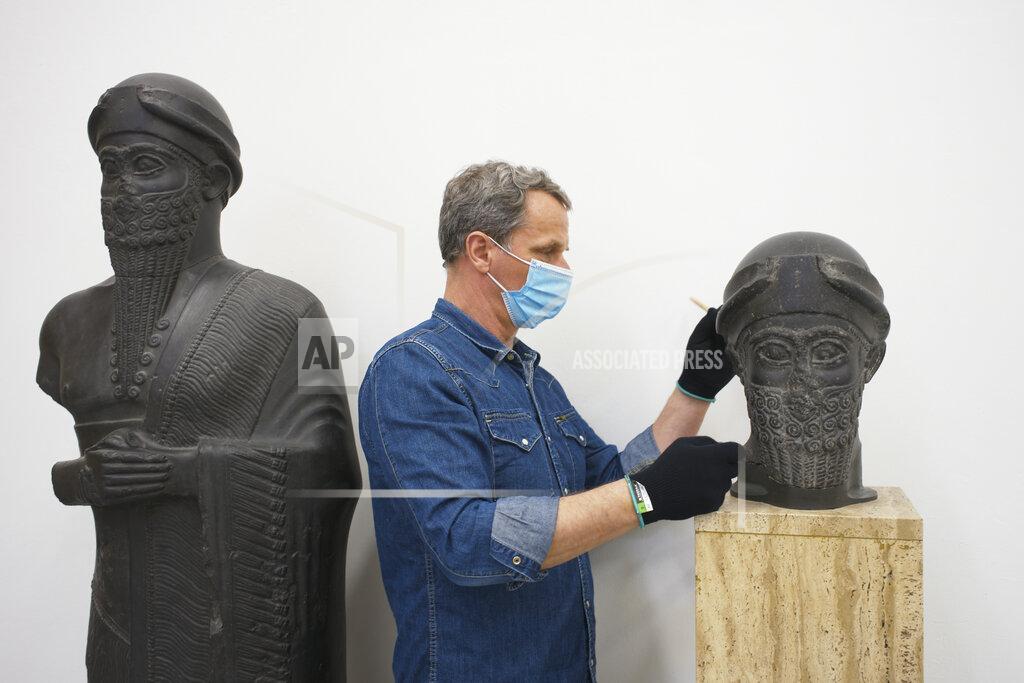 Markus Schreiber Stone restoration specialist Stefan Geismeier dusted off the black head of the statue of the Puzur-Ishtar of Mari at the Museum of the Ancient East in Berlin, Germany, Monday, March 15, 2021. Museums throughout Germany closed at the beginning of November as coronavirus cases increased. Under new regulations, some of the collections on Berlin's Museum Island, one of the city's cultural highlights and a UNESCO World Heritage site, are now allowed to re-open to visitors. (AP Photo/Markus Schreiber)