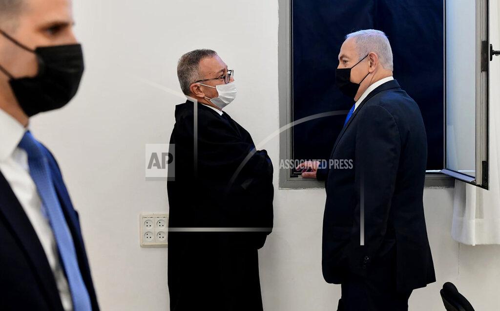 Reuven Castro Israeli Prime Minister Benjamin Netanyahu, right, speaks with his lawyers prior to a hearing at the district court in Jerusalem, Monday, Feb. 8, 2021. Netanyahu appeared in a Jerusalem courtroom Monday to respond formally to corruption charges just weeks before national elections in which he hopes to extend his 12-year rule. (AP Photo/Reuven Castro, Pool)