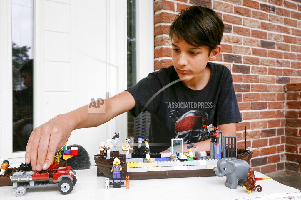 Efrem Lukatsky Danylo Boichuk, 12, shows his one of his LEGO constructions during an interview at his home in the village of Gorenichi outside Kyiv, Ukraine, on Tuesday, May 5, 2020. Ever since Ukraine imposed a lockdown to curb the spread of the coronavirus, and schools brought all their classes online, Danylo has been missing his friends _ especially a girl named Karina. (AP Photo/Efrem Lukatsky)