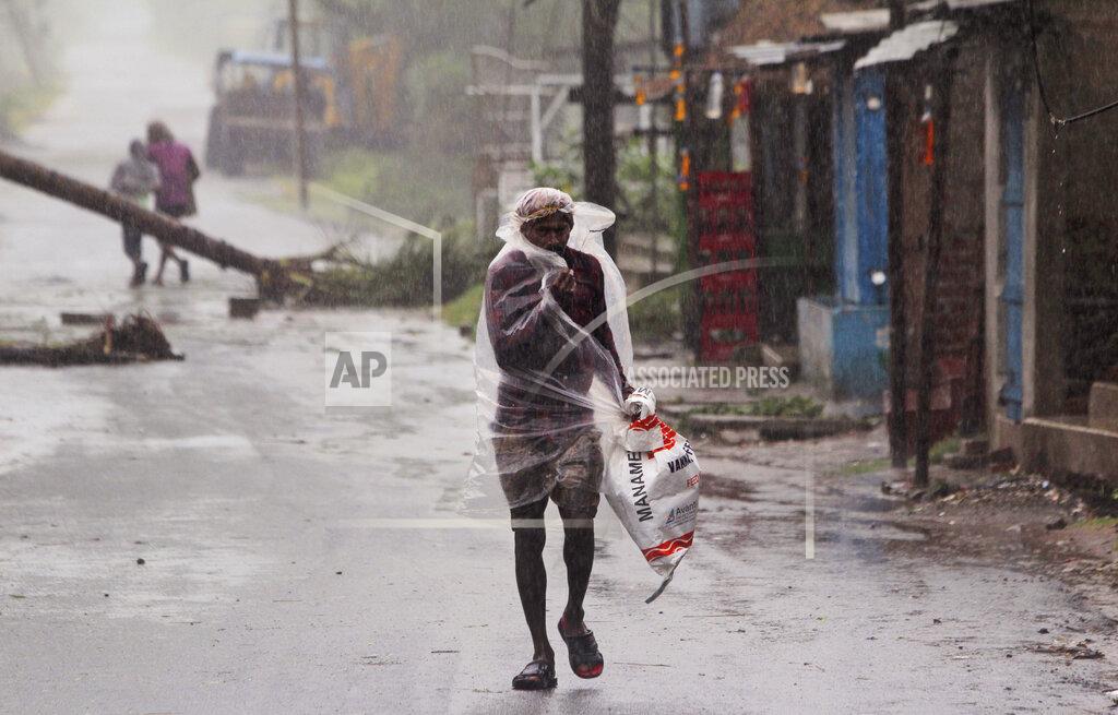 A man covers himself with a plastic sheet and walks in the rain ahead of Cyclone Amphan landfall, at Bhadrak district, in the eastern Indian state of Orissa, Wednesday, May 20, 2020. A strong cyclone blew heavy rains and strong winds into coastal India and Bangladesh on Wednesday after more than 2.6 million people were moved to shelters in a frantic evacuation made more challenging by coronavirus. (AP Photo)