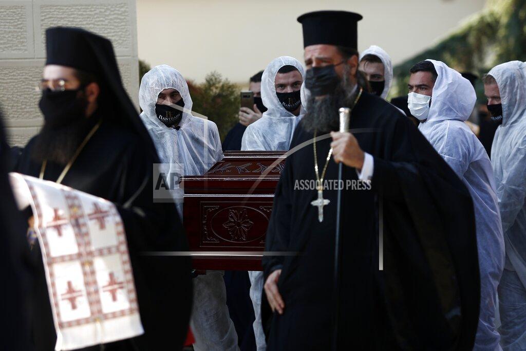 Priests wearing face masks to protect against the spread of the coronavirus, attend the funeral of senior clergyman Ioannis of Lagadas after he died of COVID-19, in Greece's Orthodox Church, in the northern city of Thessaloniki, Greece, Monday, Nov. 16, 2020. Metropolitan Bishop Ioannis of Lagadas, 62, was an outspoken advocate of maintaining communion ceremonies _ at which worshipers are given bread as well as wine with a shared spoon _ during the pandemic, arguing that there was no risk of transmission. (AP Photo/Giannis Papanikos)