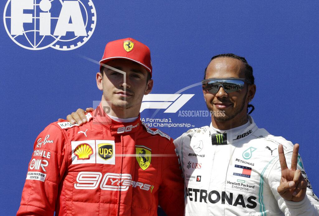 Claude Paris Mercedes driver Lewis Hamilton of Britain, right, who earned pole position, and Ferrari driver Charles Leclerc of Monaco, who came in third, posing for photos after the qualifying session at the Paul Ricard racetrack in Le Castellet, southern France, Saturday, June 22, 2019. The French Formula One Grand Prix will be held on Sunday. (AP Photo/Claude Paris)