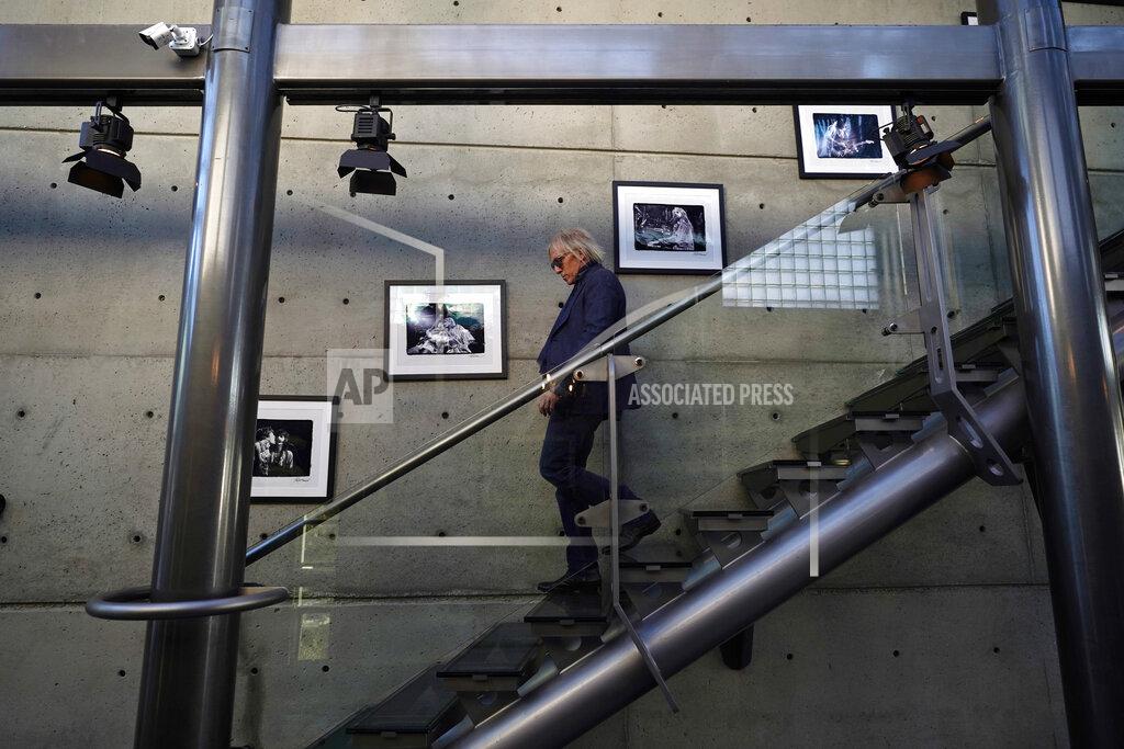Marcio Jose Sanchez Jed Leiber walks past a row of photographs of rock musicians at home Thursday, Dec. 3, 2020, in Los Angeles. (AP Photo/Marcio Jose Sanchez)