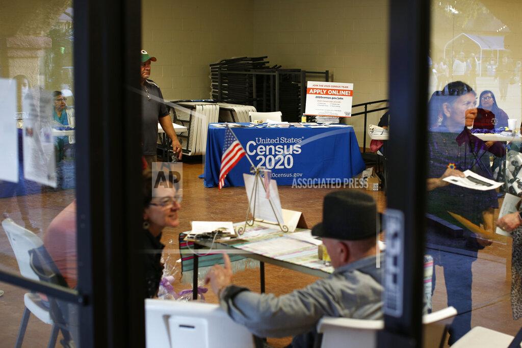 Dario Lopez-Mills FILE - In this Feb. 8, 2020, file photo, people volunteer to get people registered to vote and a booth offering employment for the upcoming 2020 census stands in the background, during the celebration of the town's 45th year since it was incorporated, in Guadalupe, Ariz. Today, nearly a third of Guadalupe's 6,500 residents say they are Native American and about 75% of all races identify as Hispanic. President Joe Biden is confronting the political risk that comes with grand ambition. As one of his first acts, the president offered a sweeping immigration overhaul that would provide a pathway to U.S. citizenship for the estimated 11 million people in the country illegally. It’s precisely the type of measure many Latino activists have longed for. (AP Photo/Dario Lopez-MIlls, File)