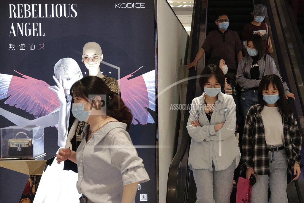 Andy Wong People wearing protective face masks to help curb the spread of the new coronavirus ride an escalator at a shopping mall in Beijing, Sunday, May 17, 2020. China on Sunday reported five new cases of coronavirus, as the commercial hub of Shanghai announced the restart of classes for kindergarteners, first-, second- and third-graders from June 2. (AP Photo/Andy Wong)