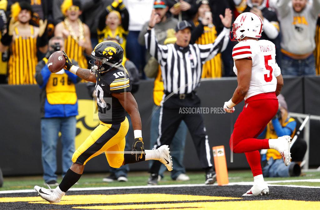 Charlie Neibergall Iowa running back Mekhi Sargent, left, celebrates after catching a 5-yard touchdown pass in front of Nebraska linebacker Dedrick Young II during the second half of an NCAA college football game, Friday, Nov. 23, 2018, in Iowa City, Iowa. Iowa won 31-28. (AP Photo/Charlie Neibergall)