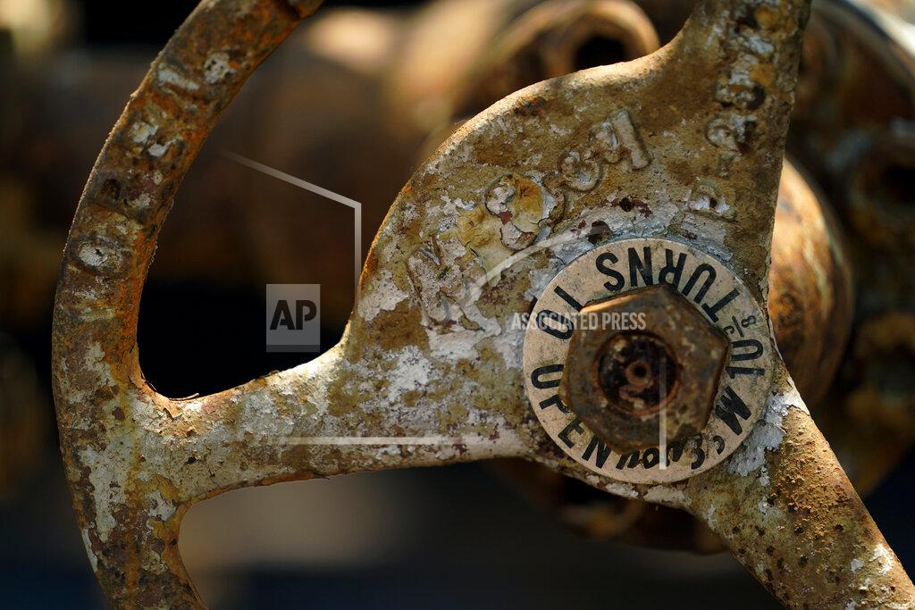 Eric Gay An equipment valve handle is seen at a site on the Rooke family ranch where an orphaned oil well is being plugged, Tuesday, May 18, 2021, near Refugio, Texas. There are 3.2 million abandoned oil and gas wells in the U.S., according to the Environmental Protection Agency. About a third were plugged with cement, which is considered the proper way to prevent harmful chemical leaks. But most, about 2.1 million by the EPA's count, haven't been plugged at all. (AP Photo/Eric Gay)