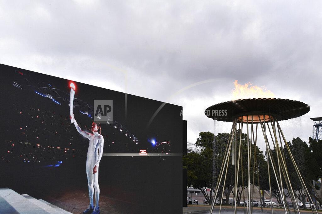 A video screen shows Cathy Freeman lighting the Olympic Cauldron as part of the 20th anniversary celebrations of the Sydney 2000 Olympic Games in Sydney, Tuesday, Sept. 15, 2020. Freeman, who lit the cauldron at the original opening ceremony and won the 400-meter race at the track in one of the country's all-time great sporting moments, said it was a wonderful gesture to have "two future stars" recognized on such a major stage ahead of the rescheduled 2020 Games in Tokyo next year. (Dean Lewins/AAP Image via AP)
