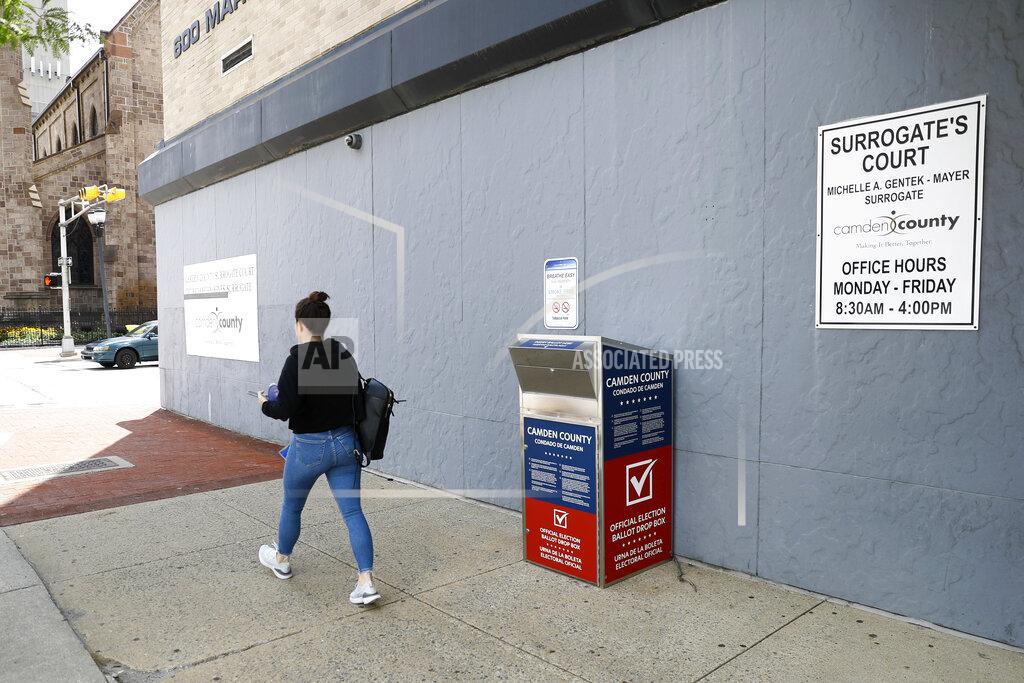 Matt Slocum FILE - In this July 1, 2020, file photo, a woman walks past a vote-by-mail drop box for the upcoming New Jersey primary election outside the Camden, N.J., Administration Building. Democrats plan to move quickly on one of the first bills of the new Congress, which would set federal election standards. The For the People Act would require states to offer early voting, same-day registration and the option of absentee voting for all registered voters. (AP Photo/Matt Slocum, File)