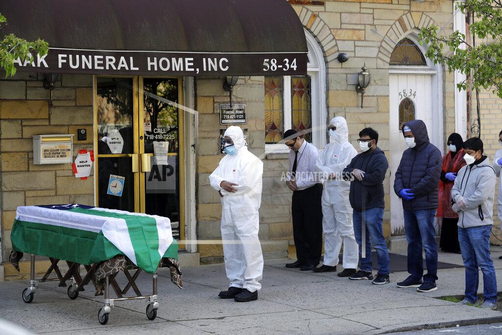 FILE - In this April 22, 2020, file photo, mourners pray as the remains of Traffic Section Commander Mohammed Chowdhury are brought out of the funeral home during his funeral in New York. Chowdhury died on April 19, 2020, from complications related to the coronavirus. Whether it's framed as American exceptionalism, American interventionism, American global standing, or a lack of it, how the world's foremost superpower moves forward following the presidential election will have a sizeable impact in various geopolitical pressure points and in the time of the pandemic. (AP Photo/Seth Wenig, File)