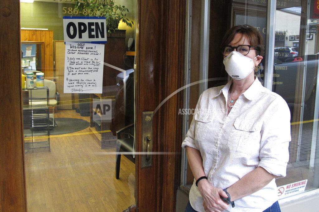 Becky Bohrer Barber Rhonda Adams poses outside her shop in downtown Juneau, Alaska, on Friday, April 24, 2020. Adams said she was excited to get back to work. (AP Photo/Becky Bohrer)