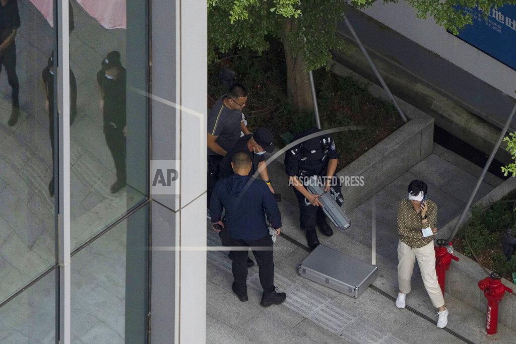 Ng Han Guan Security personnel prepare to use a device that appears to be for disabling drones as they react to something in the sky near the headquarters of the real estate developer Evergrande Group, Thursday, Sept. 23, 2021, in Shenzhen, southern China. Fears that the developer's possible default on multibillion-dollar debts might send shockwaves through global financial markets appeared to ease Thursday as creditors waited to see how much they might recover. (AP Photo/Ng Han Guan)