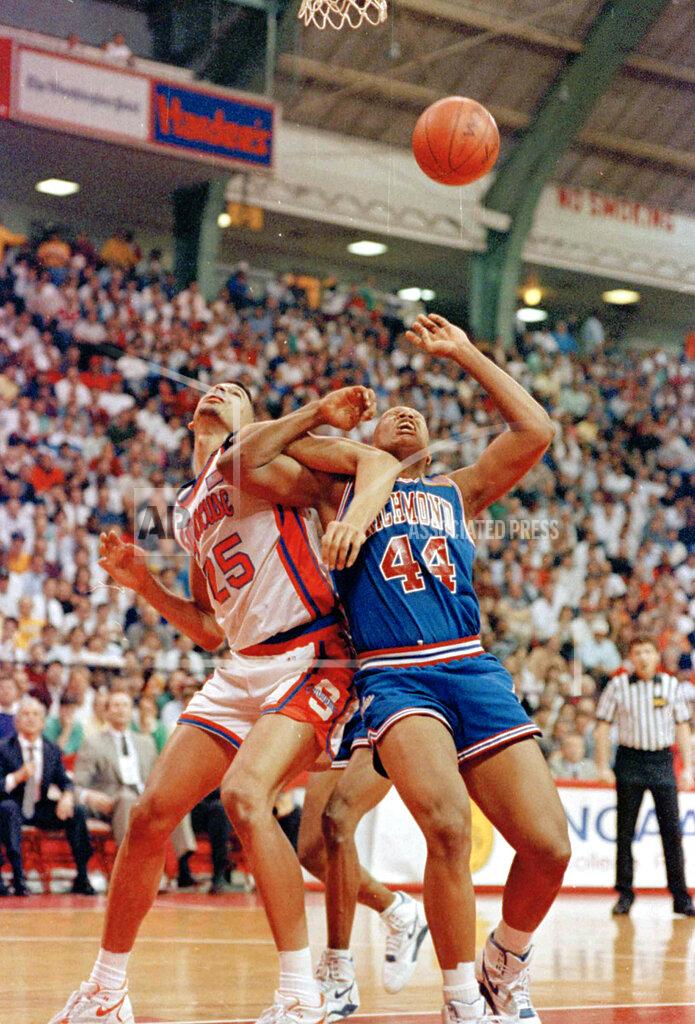 Doug Mills FILE - In this March 14, 1991, file photo, Syracuse's LeRon Ellis (25) and Richmond's Kenny Wood (44) lock arms as they watch the ball get away during the first half and an NCAA college basketball East Regional game in College Park, Md. Richmond defeated Syracuse 73-69. (AP Photo/Doug Mills, File)