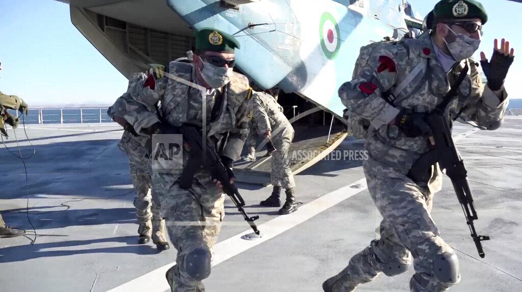 Uncredited This image made from a video released on Wednesday, Jan. 13, 2021, by the Iranian Army shows troops leaving a helicopter on Makran logistics vessel during a navy drill. Iran's navy began a short-range missile drill in the Gulf of Oman on Wednesday, state TV reported, amid heightened regional tensions over Tehran's nuclear program and a U.S. pressure campaign against the Islamic Republic. (Iranian Army via AP)