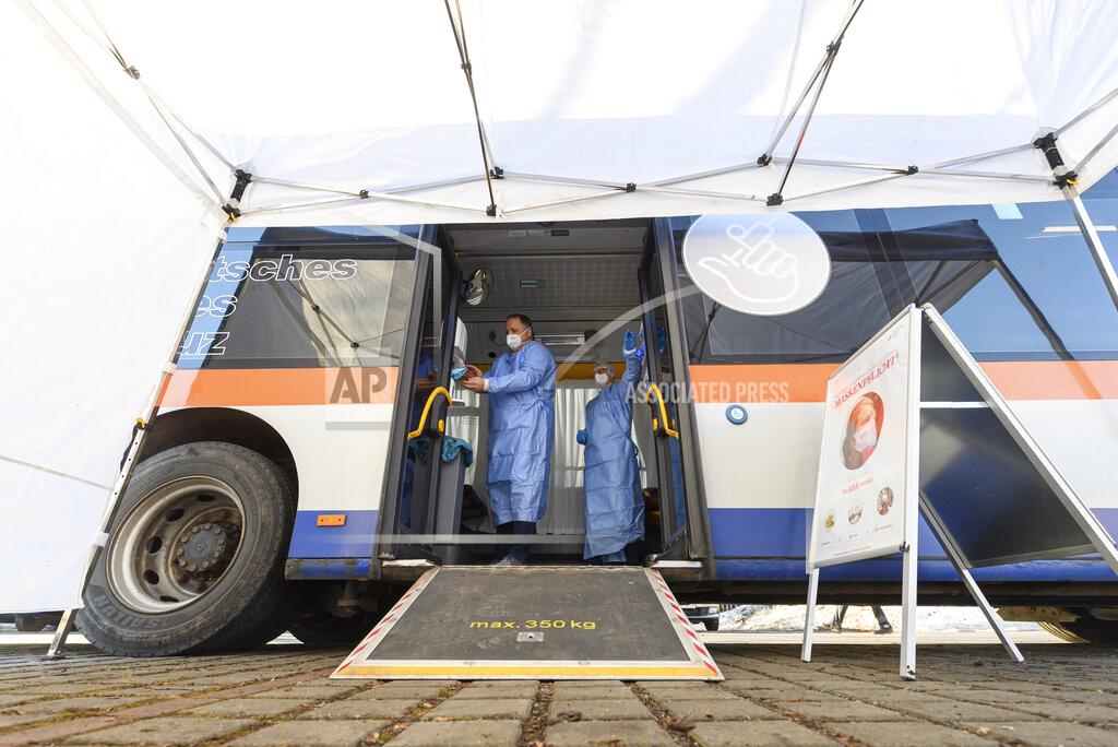 Robert Michael Medical staff prepare a bus, containing a so-called rolling vaccination centre for a the test run in Grosshartmannsdorf, Germany, Sunday, Feb. 21, 2021. Mobile vaccination centers will be used to vaccinate people against the coronavirus and the COVID-19 disease in three municipalities of German federal state Saxony. (Robert Michael/dpa via AP)