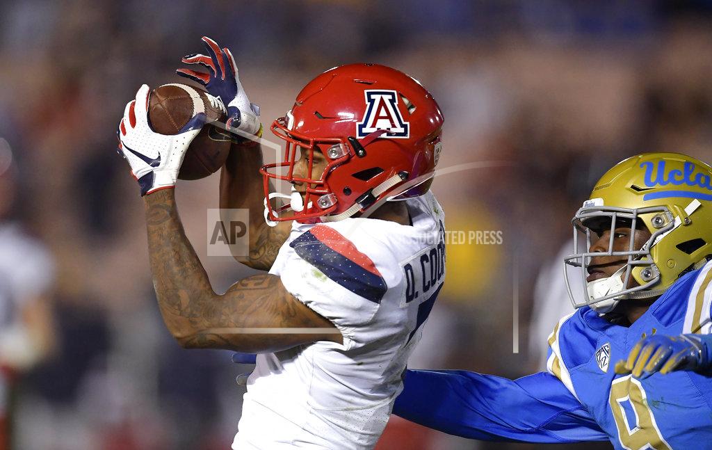 Mark J. Terrill Arizona wide receiver Devaughn Cooper, left, makes a catch as UCLA defensive back Elijah Gates defends during the second half of an NCAA college football game Saturday, Oct. 20, 2018, in Pasadena, Calif. UCLA won 31-30. (AP Photo/Mark J. Terrill)