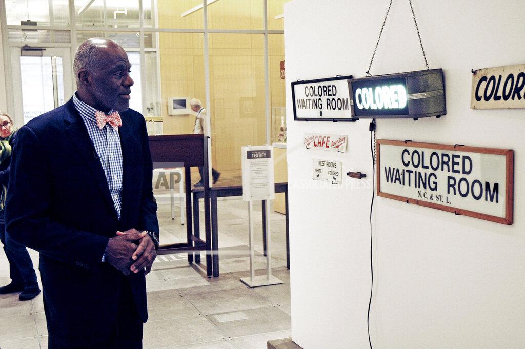 Steve Karnowski File-In this Jan. 11, 2018 file photo, Alan Page, NFL Hall of Famer and retired Minnesota Supreme Court justice, looks at a display which is among the artifacts of slavery and segregation collected by Page and his wife, Diane Sims Page. Page has counted art collection among his many life pursuits, and the former Vikings star has two of his prized pieces up for sale through a New York auction house, each valued at more than $200,000. (AP Photo/Steve Karnowski, File)