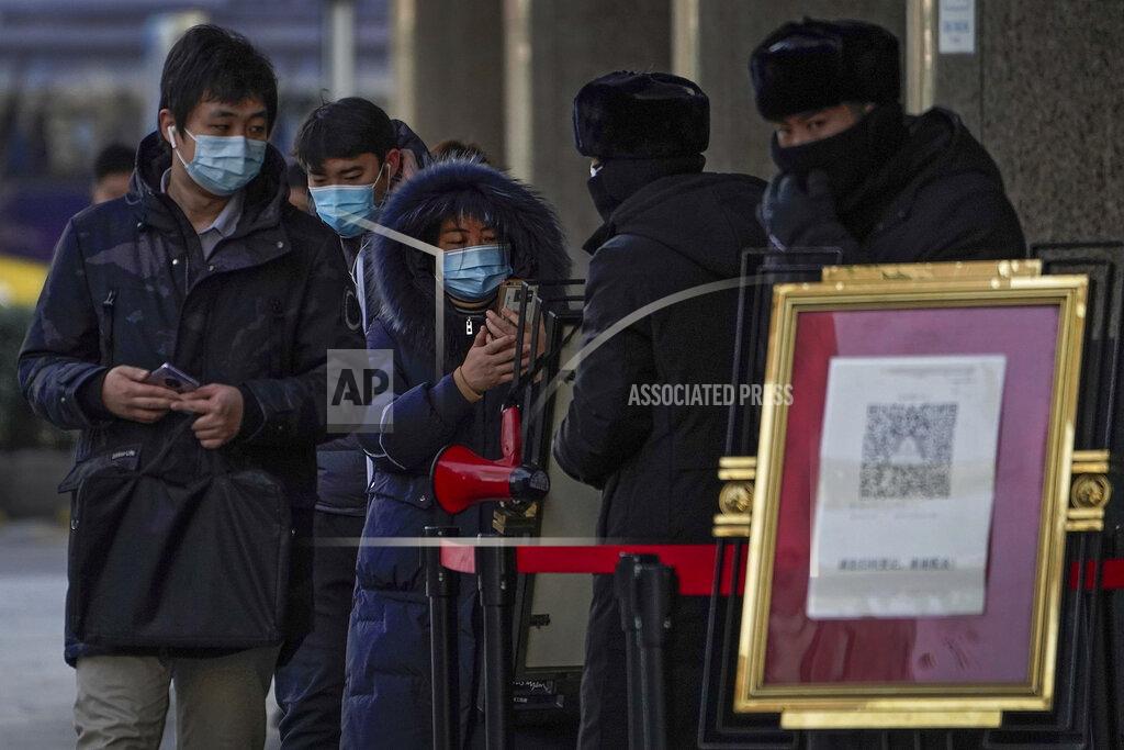 Andy Wong People wearing face masks to help curb the spread of the coronavirus use smartphones to scan their health code before entering an office building in Beijing, Tuesday, Jan. 12, 2021. Lockdowns have been expanded and a major political conference postponed in a province next to Beijing that is the scene of China's most serious recent COVID-19 outbreak. (AP Photo/Andy Wong)