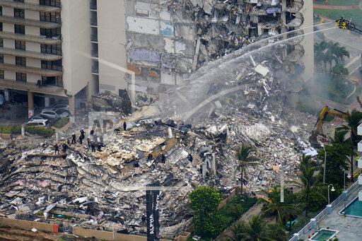 FILE - In this Friday, June 25, 2021, file photo, rescue workers work in the rubble at the Champlain Towers South Condo in Surfside, Fla. The fight over whether the site of June's deadly Florida condominium collapse should be sold for development or turned into a memorial boiled over during an emotional court hearing Thursday, Sept. 23, 2021, with some victims' relatives begging for time to find a buyer who won't put a new luxury high-rise there.(AP Photo/Gerald Herbert, File)