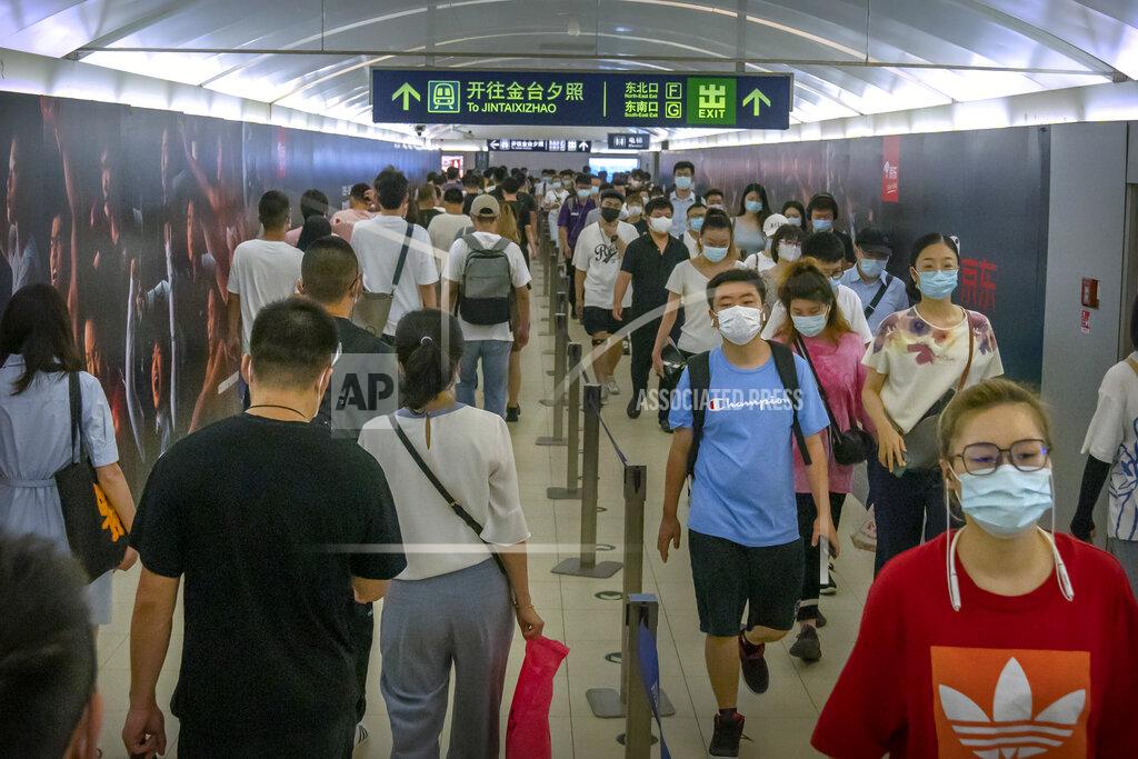 Mark Schiefelbein People wearing face masks to help protect against COVID-19 walk through a subway station during the morning rush hour in Beijing, Wednesday, Aug. 4, 2021. China's worst coronavirus outbreak since the start of the pandemic a year and a half ago escalated Wednesday with dozens more cases around the country, the sealing-off of one city and the punishment of its local leaders. (AP Photo/Mark Schiefelbein)