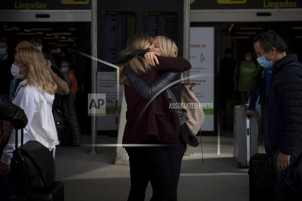 Francisco Ubilla Two women meet at Palma de Mallorca Airport on the Spanish Balearic Island of Mallorca, Spain, Saturday, March 27, 2021. Efforts in Spain to restart tourism activity is drawing a mixed picture due to a patchwork of national, regional and European rules on travel that is confusing both tourists and their hosts. (AP Photo/Francisco Ubilla)