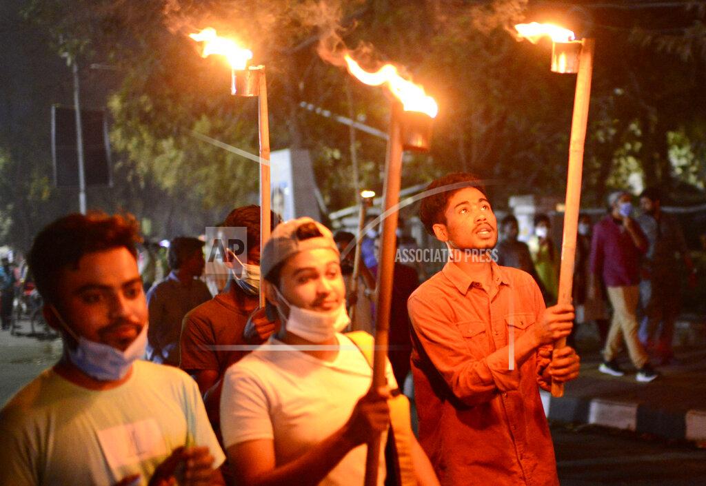 Mahmud Hossain Opu Demonstrators participate in a torch light vigil to protest the death in prison of a writer who was arrested on charges of violating the sweeping digital security, in Dhaka, Bangladesh, Friday, Feb. 26, 2021. Mushtaq Ahmed, 53, was arrested in Dhaka in May last year for making comments on social media that criticized the Prime Minister Sheikh Hasina government's handling of the coronavirus pandemic. He had been denied bail at least six times. (AP Photo/Mahmud Hossain Opu)