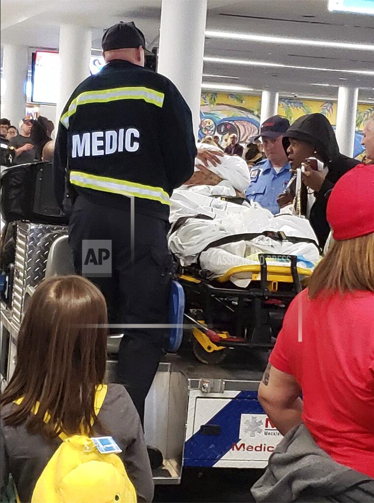 This photo provided by Eric Linne shows medics attending to a woman after giving birth on the plane at at Charlotte Douglas International Airport, Wednesday, Nov. 27, 2019 in Charlotte, N.C. News outlets report Nereida Araujo went into labor Wednesday on a flight from Tampa, Florida, to Charlotte, N.C. American Airlines spokeswoman Crystal Byrd says the flight crew radioed medics who helped deliver the baby on the plane once it landed. Passenger Eric Linne says on Facebook that a crowd burst into spontaneous applause when Araujo and the baby were brought off the plane. (Eric Linne via AP)