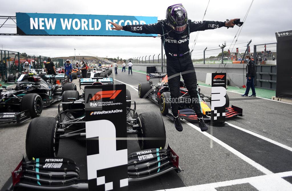 Jorge Guerrero Mercedes driver Lewis Hamilton of Britain jumps out of his car after his record breaking 92nd win at the Formula One Portuguese Grand Prix at the Algarve International Circuit in Portimao, Portugal, Sunday, Oct. 25, 2020. (Jorge Guerrero, Pool via AP)
