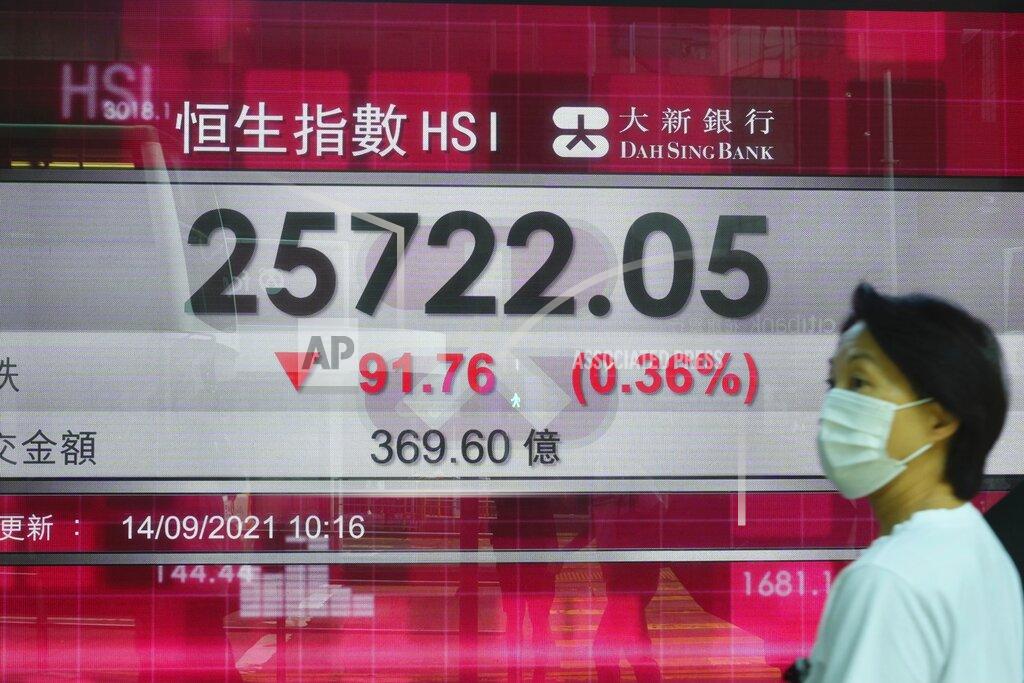 Vincent Yu A woman walks past a bank's electronic board showing the Hong Kong share index at Hong Kong Stock Exchange in Hong Kong Tuesday, Sept. 14, 2021. Asian stock markets were mixed Tuesday as investors waited for an update on U.S. inflation that has been stronger than expected. (AP Photo/Vincent Yu)