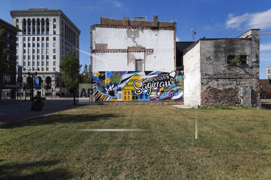 Charles Rex Arbogast Buildings from different eras of the city's history surround an empty lot in downtown Saginaw, Mich., Monday, June 29, 2020. President Donald Trump won Saginaw county by just over 1,000 votes in 2016, capitalizing on the rusting industrial city's frustrations and its dislike of Democrat Hillary Clinton. (AP Photo/Charles Rex Arbogast)
