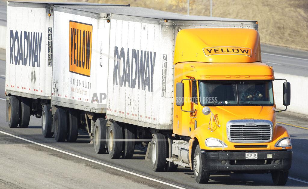 FILE - In this Feb. 2, 2010, file photo, a Yellow Freight/Roadway Express truck travels east on I-70, near Lecompton, Kan. Congressional watchdogs are questioning the government’s decision to award a $700 million coronavirus relief loan to a struggling trucking company on grounds its operations are critical for maintaining national security. YRC Worldwide provides transportation and logistics services, such as delivering food, electronics and other supplies to military locations around the country. (AP Photo/Orlin Wagner, File)