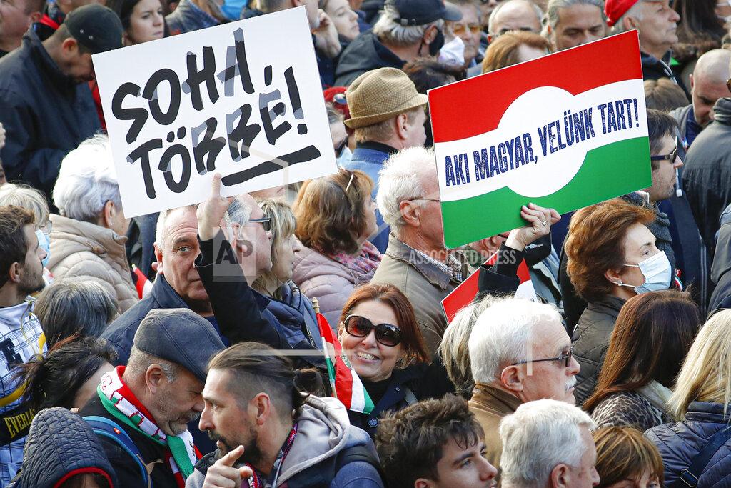 Laszlo Balogh A woman holds a banne that read "Never Again" during a march marking the 65th anniversary of the 1956 Hungarian revolution, in Budapest, Hungary, Saturday, Oct. 23, 2021. Thousands of supporters of Prime Minister Viktor Orban, who is expected to deliver a speech marking the 65th anniversary of the 1956 Hungarian revolution, march in Budapest, Hungary to demonstrate loyalty to his right-wing government. (AP Photo/Laszlo Balogh)