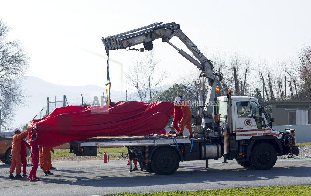 Scuderia Ferrari Mission Winnow's Sebastian Vettel's car is lifted by a crane during the Formula One pre-season testing session at the Barcelona Catalunya racetrack in Montmelo, outside Barcelona, Spain, Friday, Feb. 21, 2020. (AP Photo/Joan Monfort)