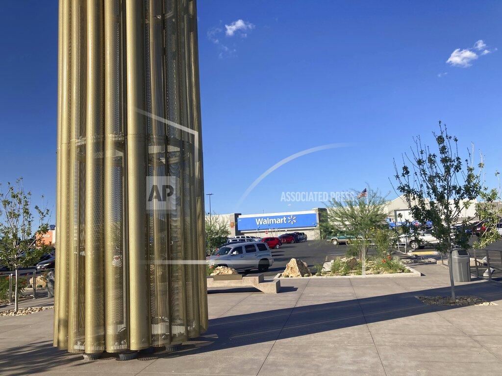 Morgan Lee A towering memorial in the form of a giant candle to the victims of a mass shooting in El Paso, Texas, casts a shadow on Thursday, Aug. 26, 2021. The August 2019 massacre of 23 people at the adjacent Walmart store prompted many people to buy guns for personal protection. A new "constitutional carry" law in Texas allows most gun owners age 21 and older to carry a holstered handgun — concealed or not — in public without getting a license and related training. (AP Photo/Morgan Lee)
