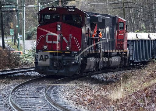 FILE - In this Nov. 27, 2020, file photo, a Canadian National rail worker stands on an idle locomotive as protesters opposed to the Trans Mountain pipeline expansion block rail lines, in Burnaby, British Columbia. On Tuesday, Oct. 19, 2021, Canadian National announced that CEO JJ Ruest is retiring instead of staying to fight against an investor who has been pushing for his ouster. (Darryl Dyck/The Canadian Press via AP, File)