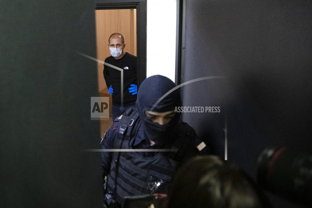 Pavel Golovkin A police officer and an investigator stands behind the door of the apartment of jailed opposition leader Alexei Navalny in Moscow, Russia, Wednesday, Jan. 27, 2021. Police are searching the Moscow apartment of jailed Russian opposition leader Alexei Navalny, another apartment where his wife is living and two offices of his anti-corruption organization. Navalny's aides reported the Wednesday raids on social media. (AP Photo/Pavel Golovkin)