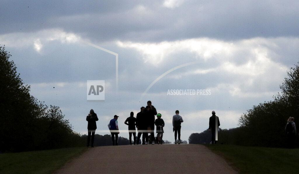Frank Augstein People walk on the long walk towards Windsor Castle, Windsor, England, Sunday, April 11, 2021, after the announcement of the death of Britain's Prince Philip on Friday. Britain's Prince Philip, the irascible and tough-minded husband of Queen Elizabeth II who spent more than seven decades supporting his wife in a role that mostly defined his life, died on Friday. (AP Photo/Frank Augstein)