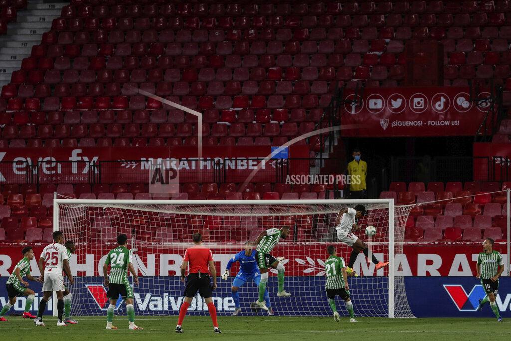 Str Sevilla and Betis players duel for the ball during their Spanish La Liga soccer match in Seville, Spain, Thursday, June 11, 2020. With virtual crowds, daily matches and lots of testing for the coronavirus, soccer is coming back to Spain. The Spanish league resumes this week more than three months after it was suspended because of the pandemic, becoming the second top league to restart in Europe. The Bundesliga was first. The Premier League and the Italian league should be next in the coming weeks. (AP Photo)