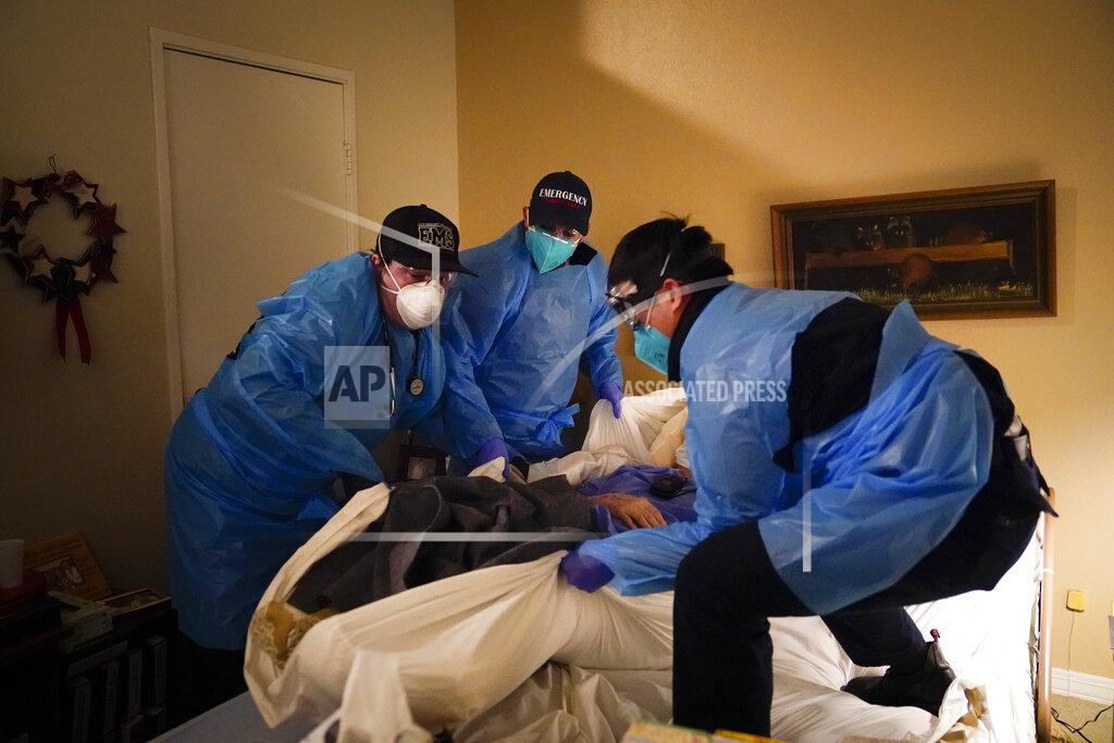 Jae C. Hong Emergency medical workers Jacob Magoon, from left, Joshua Hammond and Thomas Hoang lift a patient onto a gurney in Placentia, Calif., Saturday, Jan. 9, 2021. EMTs and paramedics have always dealt with life and death — they make split-second decisions about patient care, which hospital to race to, the best and fastest way to save someone — and now they're just a breath away from becoming the patient themselves. (AP Photo/Jae C. Hong)