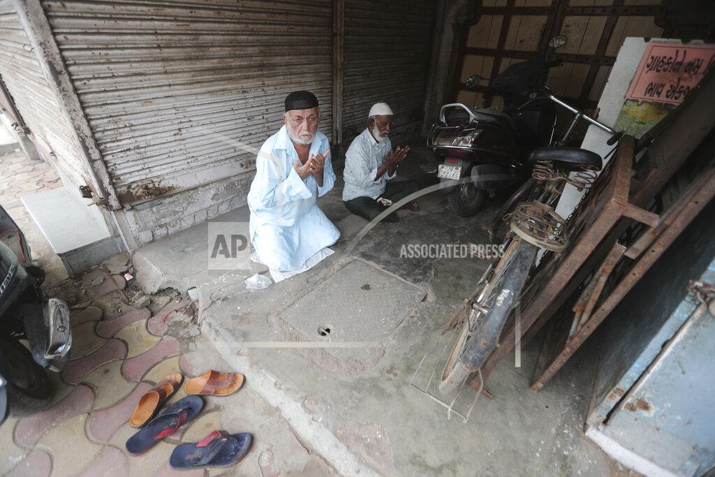 Ajit Solanki Indian Muslims offer Eid al-Adha prayers in front of a closed shop outside Jama Masjid in Ahmedabad, India, Saturday, Aug. 1, 2020. Eid al-Adha, or the Feast of the Sacrifice, is observed by sacrificing animals to commemorate the prophet Ibrahim's faith in being willing to sacrifice his son. (AP Photo/Ajit Solanki)