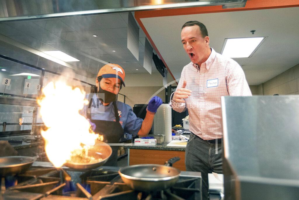 Ben Swanson During filming for the Denver Broncos' 2021 schedule release video, former quarterback and current "intern" Peyton Manning tries his hand at cooking with lead chef Wendy Jaramillo at UCHealth Training Center on Tuesday, May 10, 2021 in Englewood, Colo. Schedule release day has become a competition across the NFL between the social media departments of teams to see whose video creates the biggest impression.(Ben Swanson/Denver Broncos via AP)
