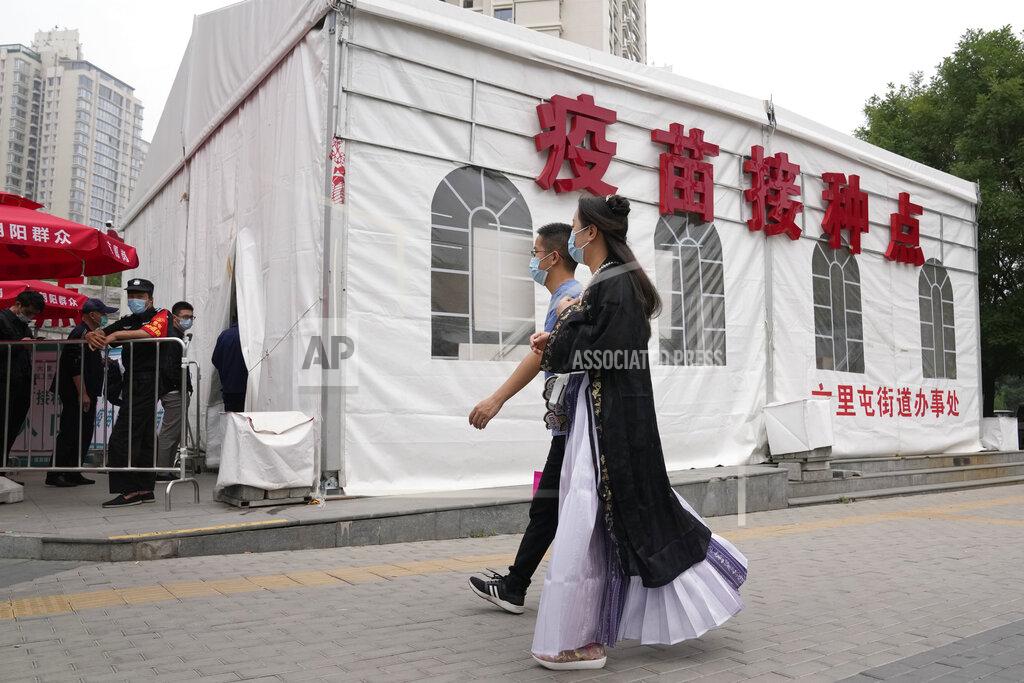 Ng Han Guan Residents line up outside a tent with the words " Vaccination Point" in Beijing on Wednesday, June 2, 2021. After a slow start, China is now doing what virtually no other country in the world can: harnessing the power and all-encompassing reach of its one-party system and a maturing domestic vaccine industry to administer shots at a staggering pace. (AP Photo/Ng Han Guan)